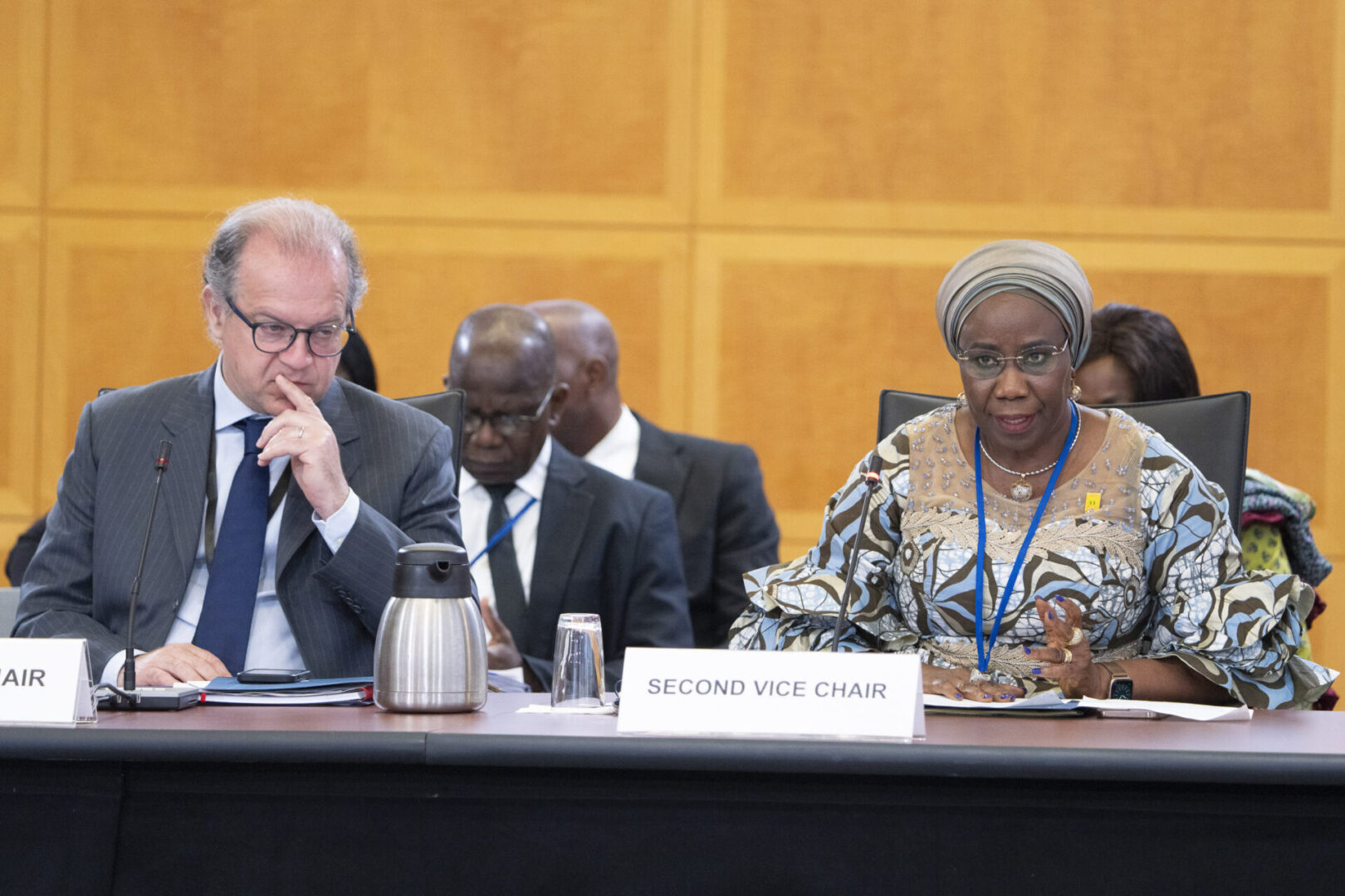 Woman in headscarf at meeting table.