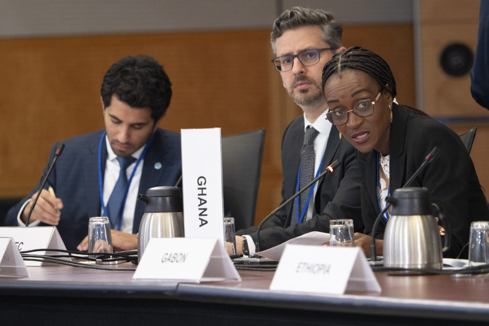 Three people sitting at a table, discussing.