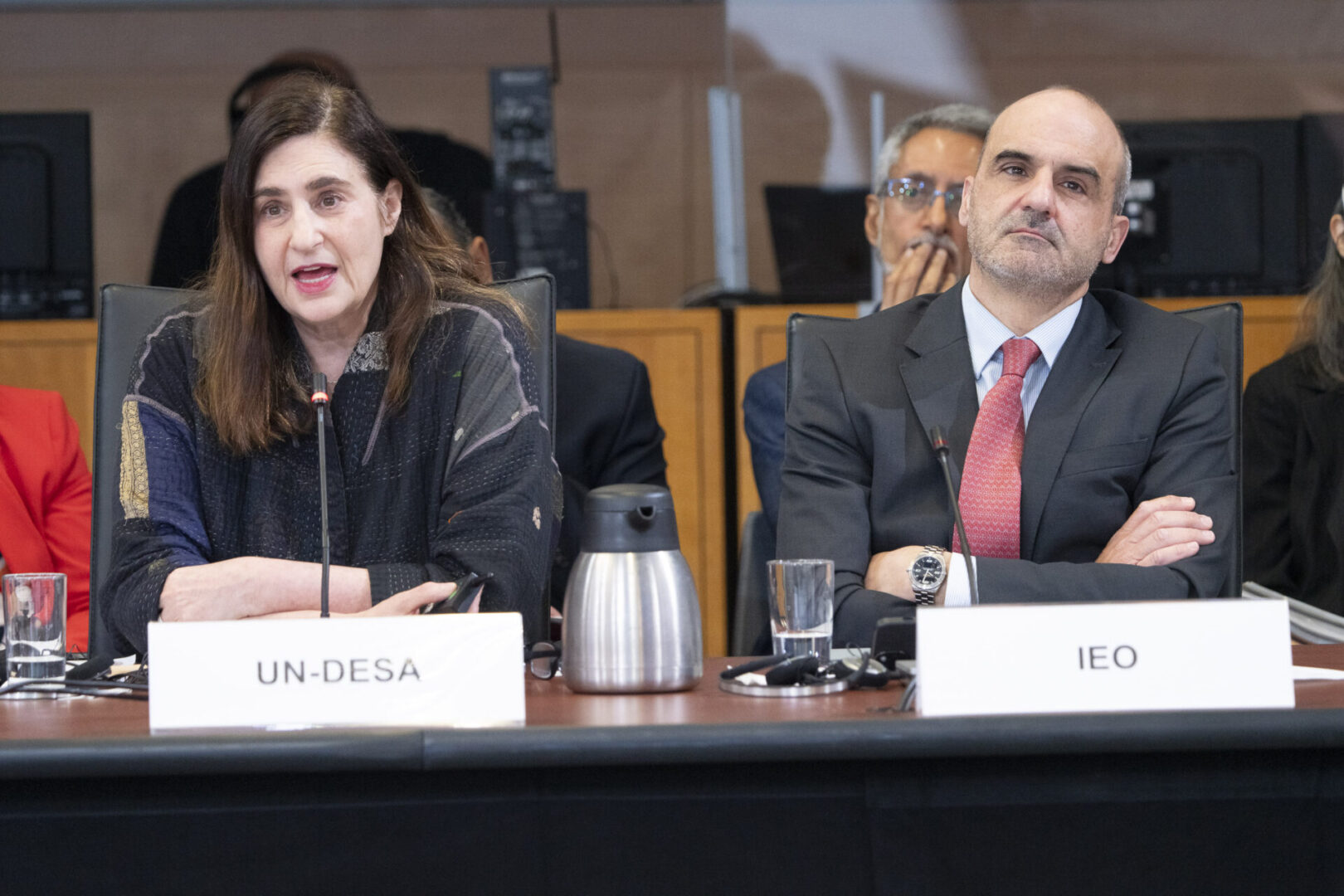 Two people sitting at a conference table.